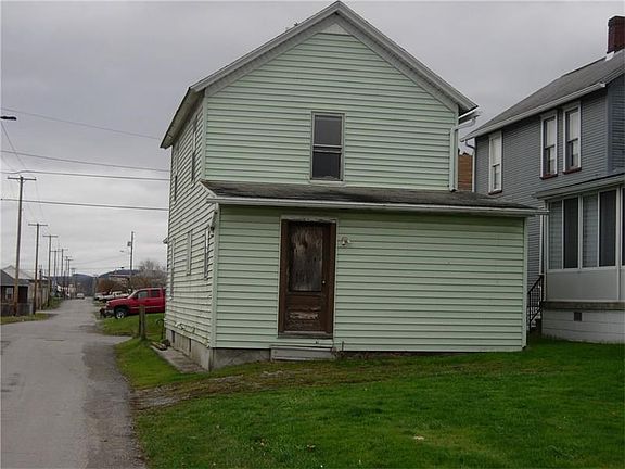 Rear view of home showing one story addition which is located directly off the kitchen.  This room would be ideal for dining area, den or bedroom.
