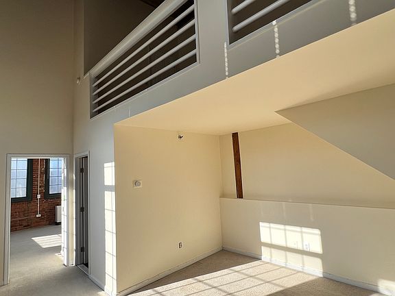View of living room, loft and entry into bedroom