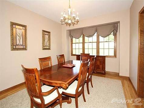 The dining room features a hardwood boarder and a large window for natural sunlight.