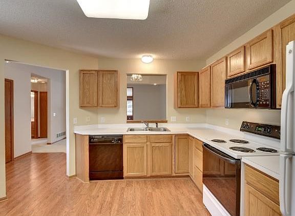 Oak cabinets and laminate flooring throughout kitchen and entryway.