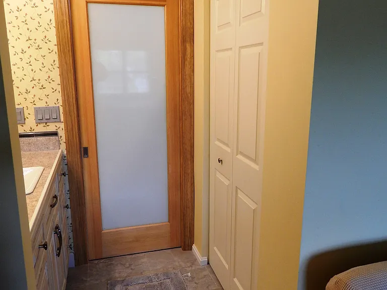 Master ensuite frosted glass pocket door closed for privacy.