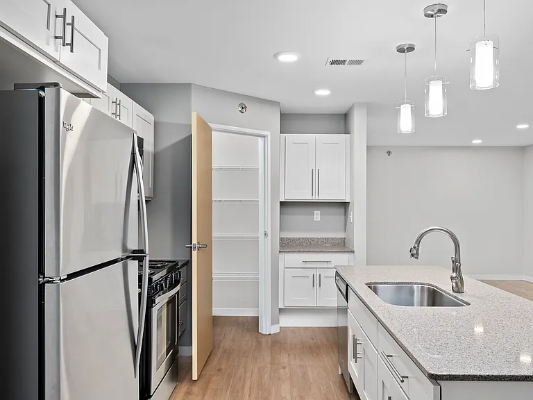 Modern kitchen with stainless steel appliances, stylish pendant lighting, and ample cabinet space. Modern kitchen with stainless steel appliances, stylish pendant lighting, and ample cabinet space.
