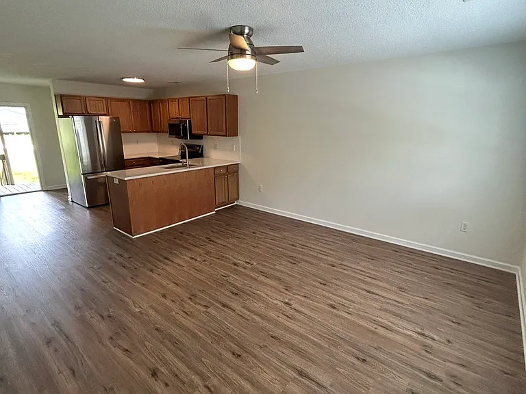 Spacious living room with brand new LVP flooring, lighting, and fan!