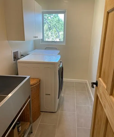 Laundry room with large double utility sink and top-of-the-line front load washer and dryer