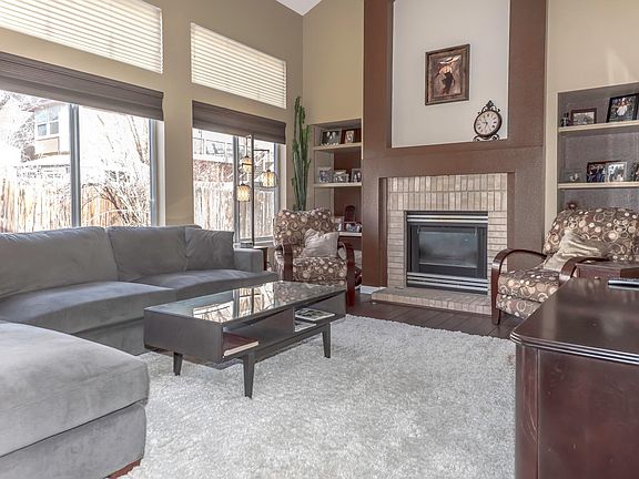 Living room with vaulted ceilings opens to kitchen.