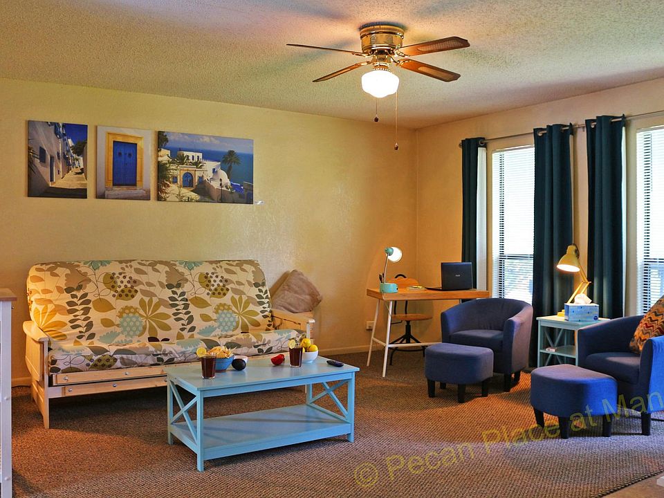 Large living room with futon, barrel chairs, desk and chair.
