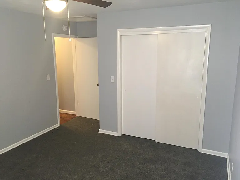Larger bedroom at rear of unit, two windows, nice sized closet, ceiling fan.