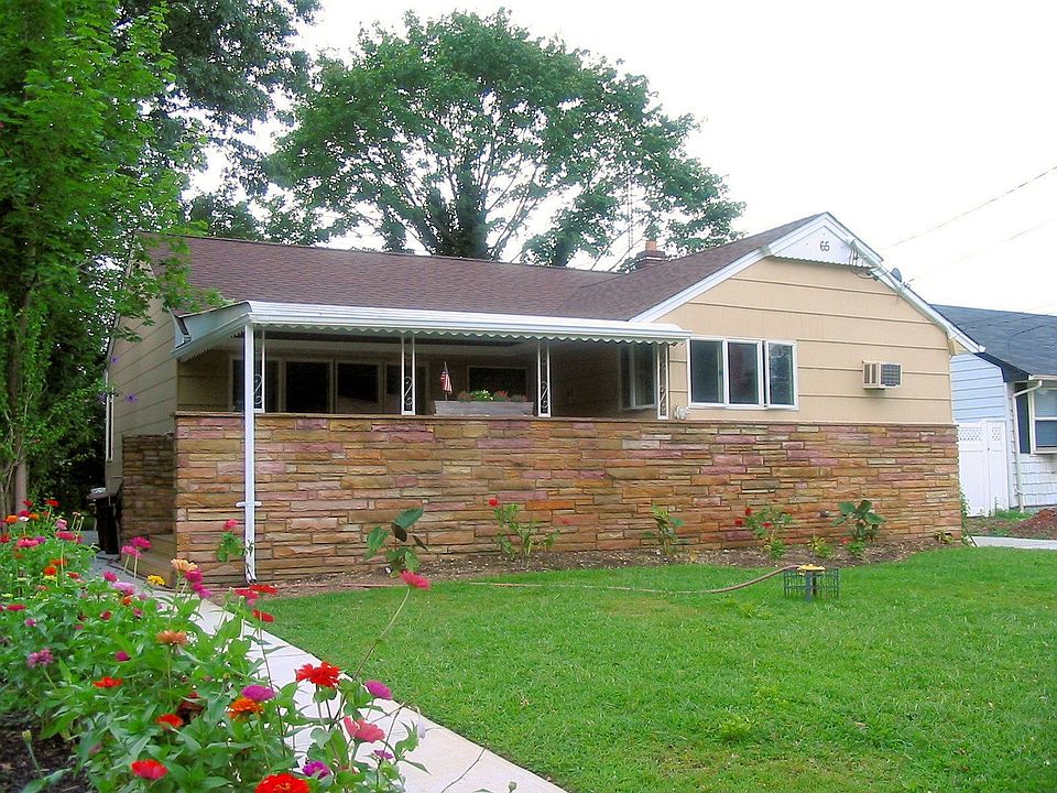 NATURAL STONE WALL SEPARATES FRONT PORCH FROM STREET VIEW
