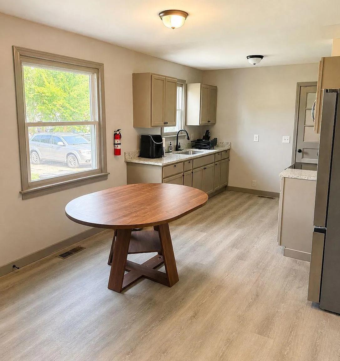 Eat-in kitchen with ample cabinet storage, roomy counters, and a large window beside the dining area.