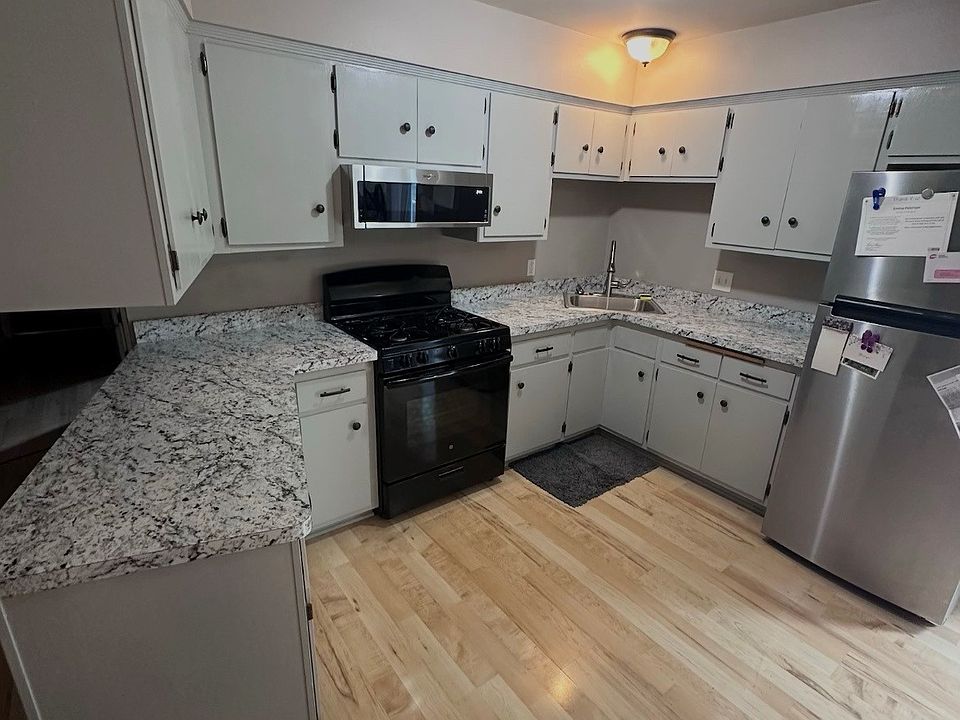 Kitchen with ample cabinet space. NEW countertops, over-the-stove microwave and sink.