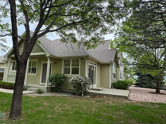 Capture the charm of the home with a side view showcasing the beautiful flowers, lush yard, and mature trees that enhance its appeal.