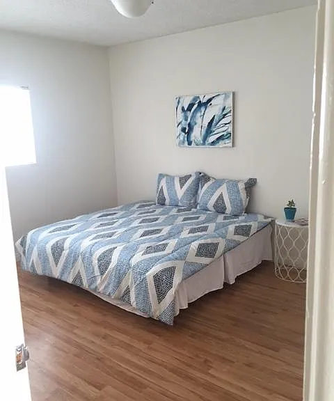 Bedroom, with East facing windows. Double slidable closet with built in shelving above.