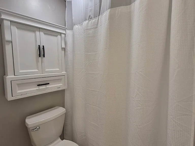 Shower curtain rod is "rounded" out for extra shower space; hung extra high for even more space. Shower curtain/liner provided by Landlord.