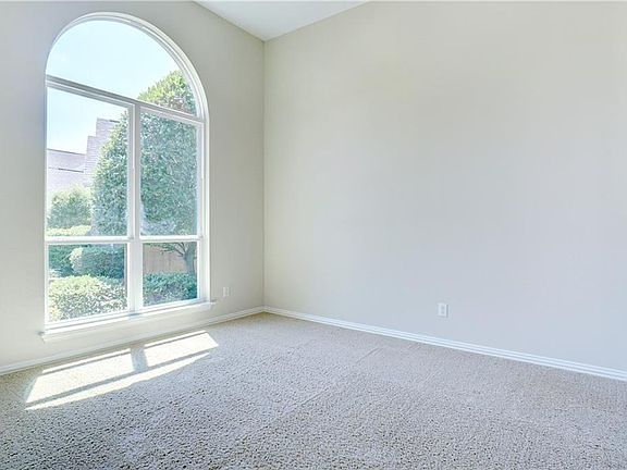Formal living area with picturesque window and high ceiling