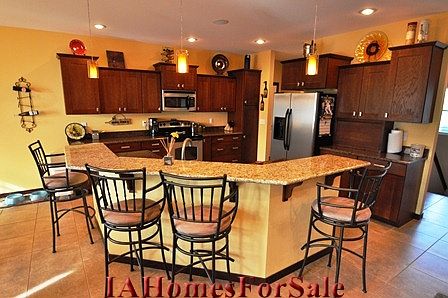 Kitchen has granite island and cherry mission style cabinets