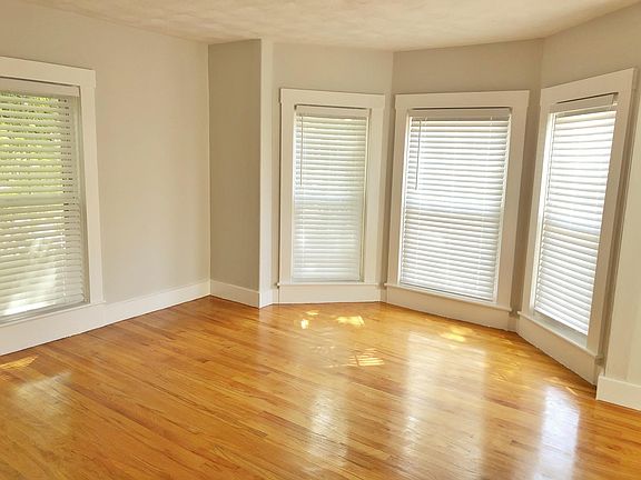 Hardwood first bedroom with bay window and walk-in closet.