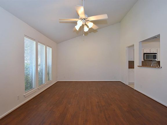 Another view of the front room featuring high ceiling and access to kitchen.