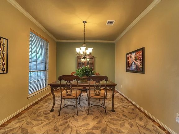 Dining room with crown molding and wood floors.