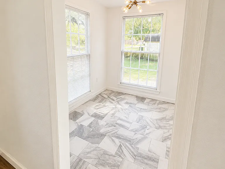 Well lit dining area with original vintage windows, new tile, and light fixture. 

Photo Note: Photos have been lightly enhanced to improve lighting and image quality. Colors, finishes, and exterior conditions may vary slightly during in-person viewing.
