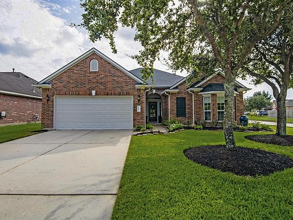 Landscaping includes knockout roses, foxtail ferns and a recirculating fountain.