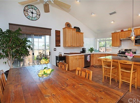Dining area is open to the remodeled kitchen. Ceiling fan, vaulted ceiling and clerestory windows make this space light, bright and airy.