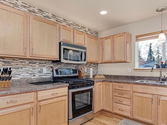 Stainless Steel Appliances include a side-by-side refrigerator, dishwasher, built-in microwave, gas range, and oven