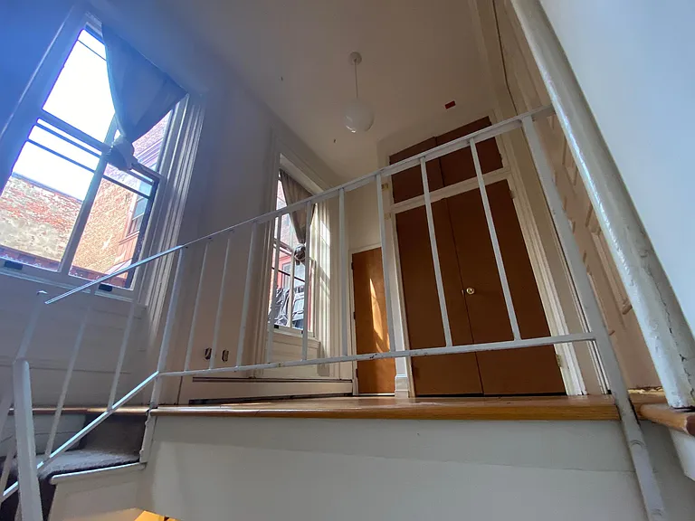 stairs to the lower living room and kitchen area, and a door to the hallway. Main entrance to apartment