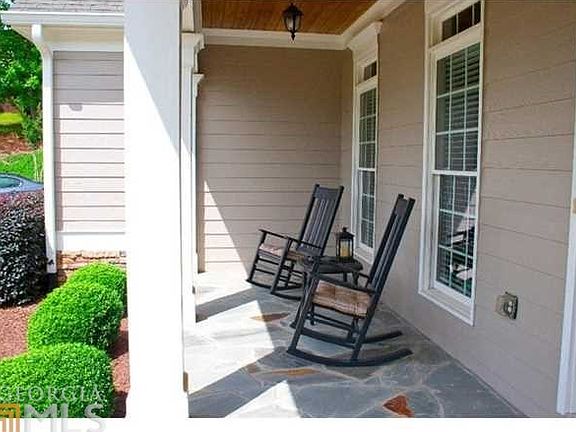 Rocking Chair front porch overlooking freshly manicured lawn. Rock flooring leads into soaring 2 sto