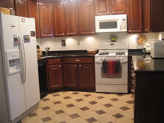 Kitchen features granite, custom tile, cherry cabinets, recessed lighting