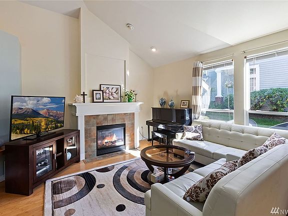 Great room with vaulted ceilings, gas fireplace, bamboo floors located next to both the kitchen as well as the dining room.