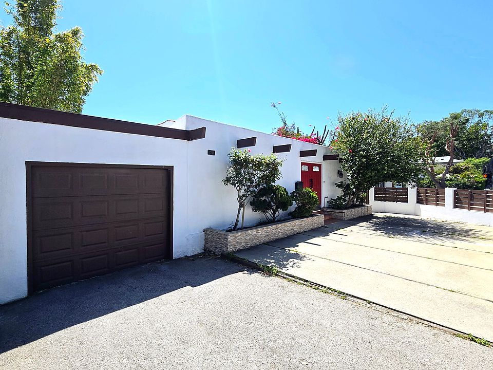Front view of the house showing the garage, driveway, fence and doorway that leads directly into the Courtyard
