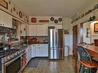 Large kitchen with breakfast bar, gas range and big refrigerator.