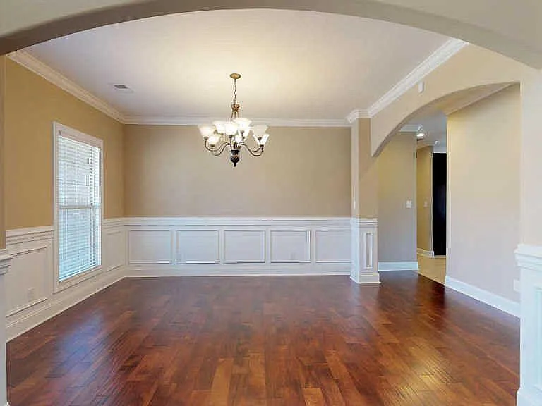 Elegant spacious dining room featuring graceful arches, crown molding and accent chair rail.