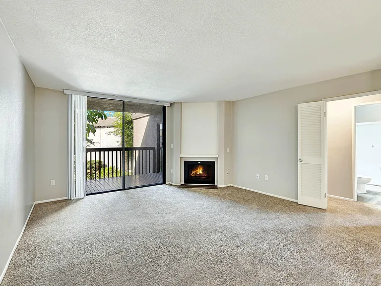Lake Dianne Apartment Homes Two Bedroom living room with a fireplace and sliding glass doors.