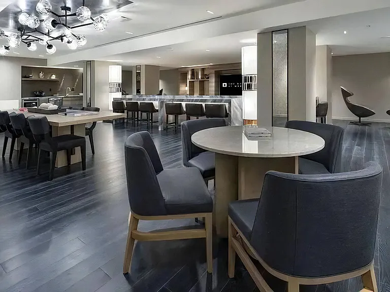 Clubhouse With Multiple Seating Areas, Tables, and Statement Lighting