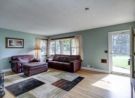 Large sun-filled living room! Warm decor & gorgeous gleaming hardwood floors throughout main level!