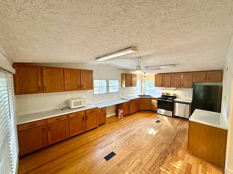 Very gracious kitchen with plenty of cabinets and countertops, including a lower desk-height countertop for a place to sit and work. Lots of natural light.