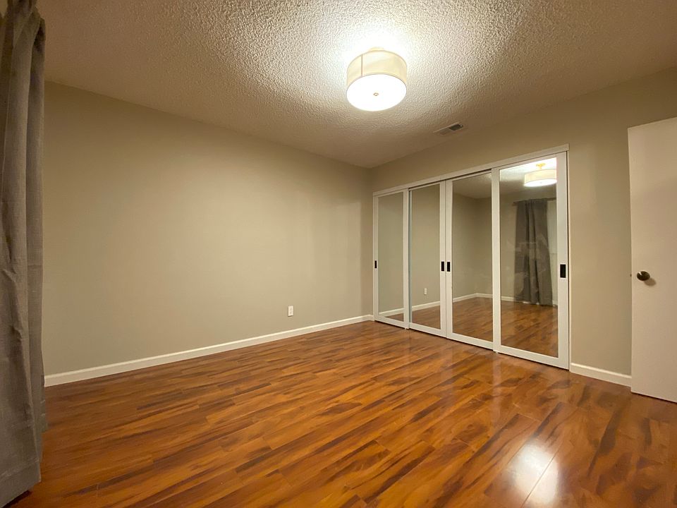 Bedroom with sliding mirrored paneled wardrobe doors