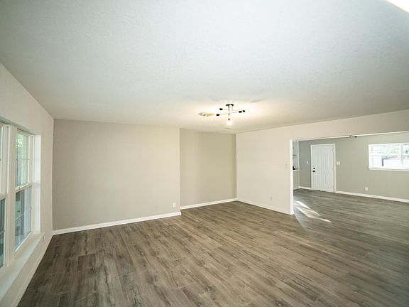 Living room with view into dining room + kitchen