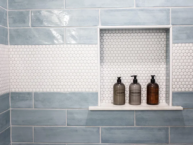 Tiled shower surround with a built-in recessed niche shelf for convenient storage of bath essentials.