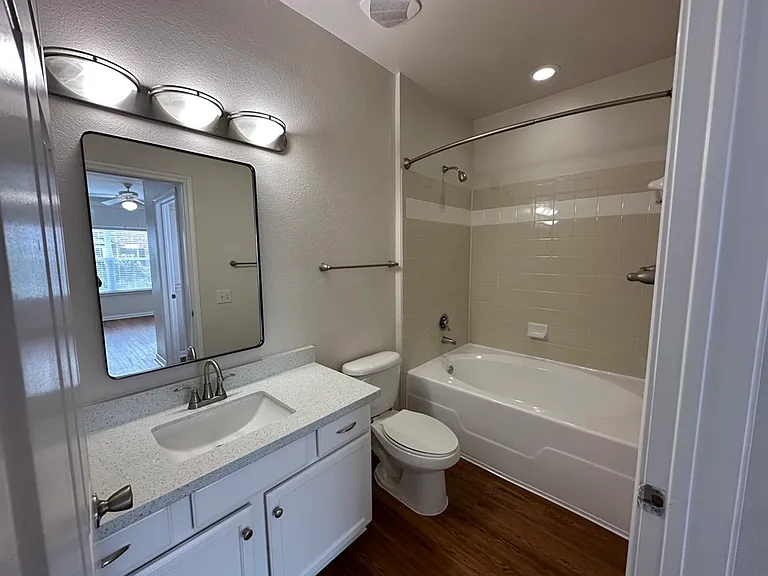 Modern bathroom with elegant vanity, large mirror, and polished fixtures; features a cozy bathtub with tiled walls and warm lighting. Modern bathroom with elegant vanity, large mirror, and polished fixtures; features a cozy bathtub with tiled walls and wa