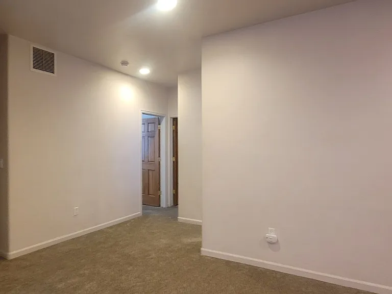 Family room looking to the mechanical room and storage closet on the left. In the middle is the stair landing, 2nd guest room, and guest bathroom