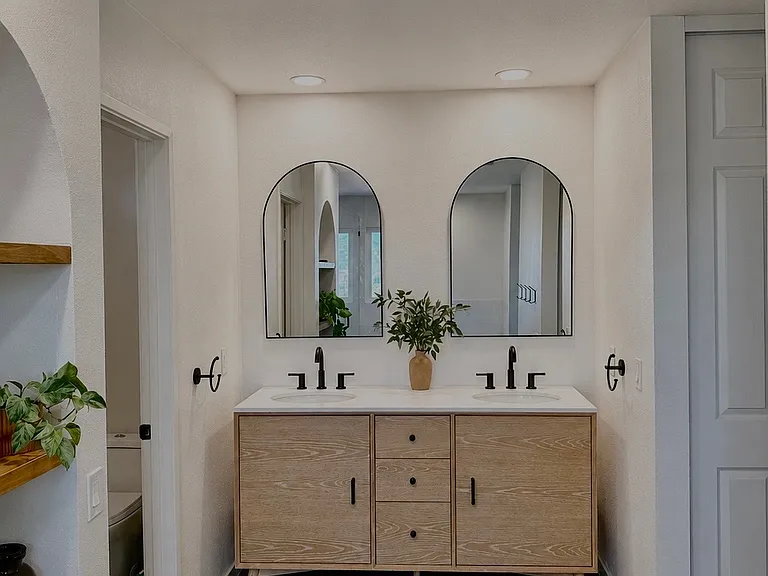 Beautifully remodeled primary bathroom featuring a custom dual-sink vanity, designer mirrors, premium fixtures, and sophisticated contemporary finishes. Spacious and thoughtfully designed to provide both luxury and functionality.