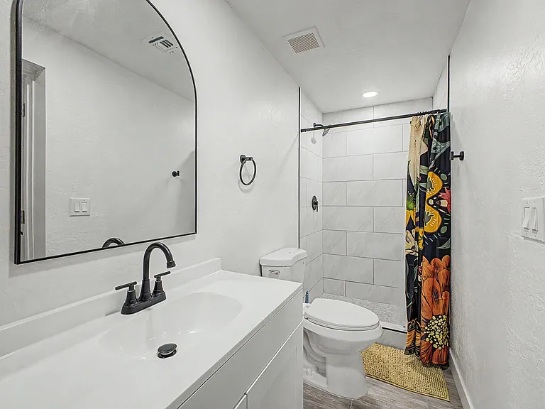 Updated bathroom with a wide vanity, matte-black fixtures, and a tiled walk-in shower for easy daily use.