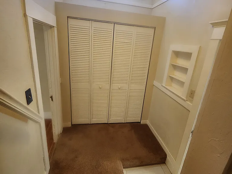 Stairs landing at bottom, with closet and access to kitchen and main bedroom