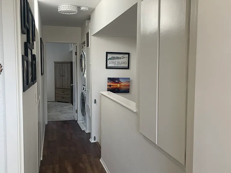 Hallway between bedrooms, includes linen closet, storage closet, and washer and dryer