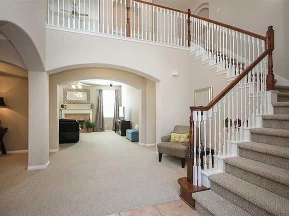 Side placed stairway and lovely seating area. Great place for a Christmas tree! Arched doorways are a show stopper!