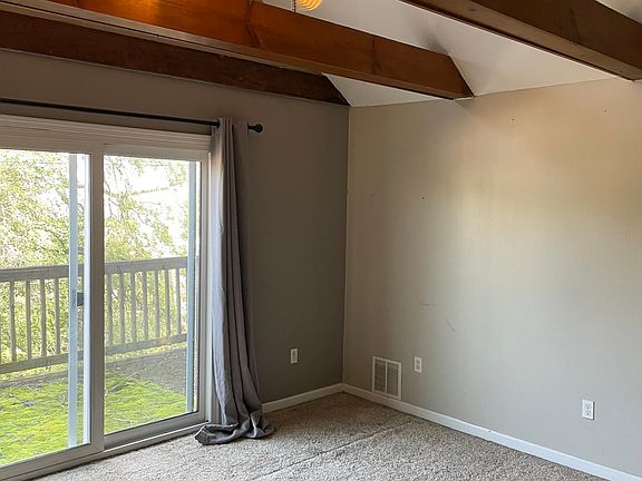 Main bedroom with a cathedral ceiling and walk out private deck.