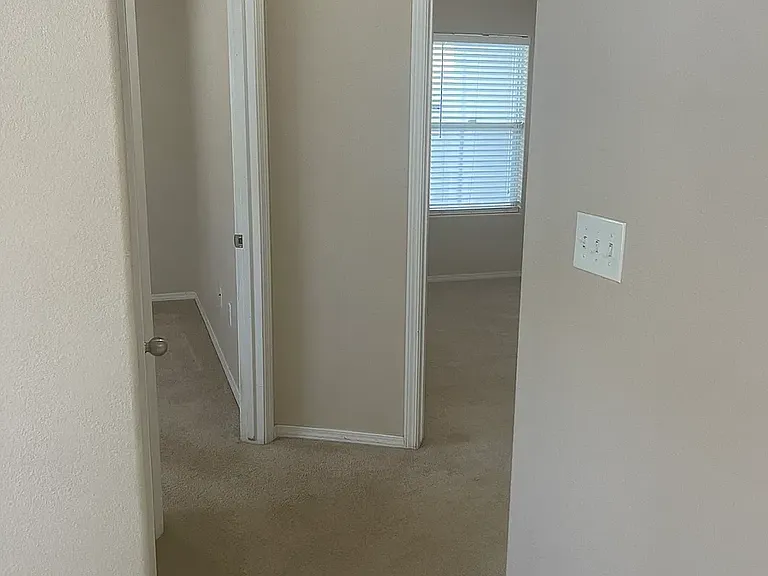Hallway from living room leading to 2 bedrooms and guest bathroom.