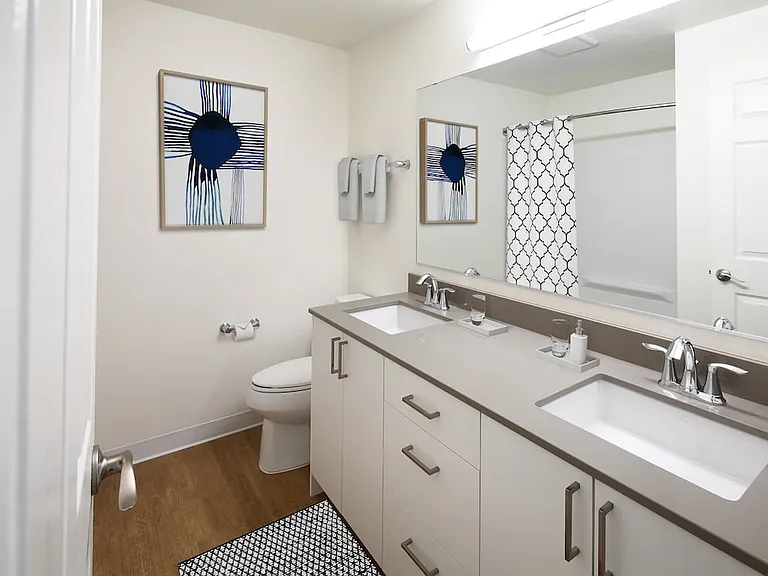 Renovated Package I bath with grey quartz countertop, white cabinetry, and hard surface flooring